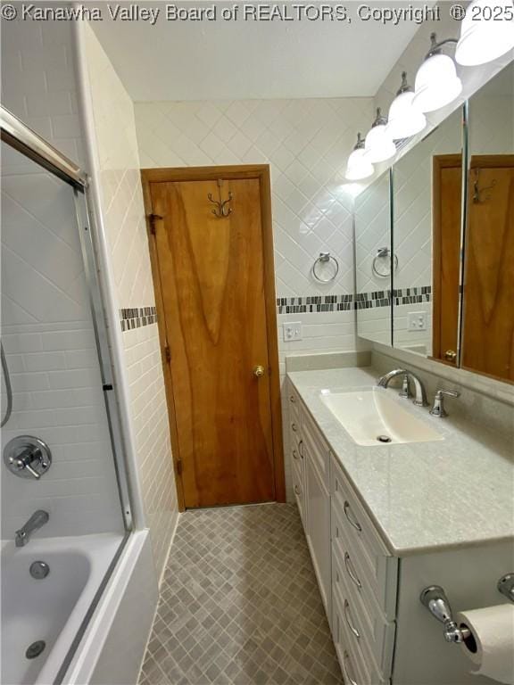 bathroom with tile walls, vanity, and shower / bathing tub combination