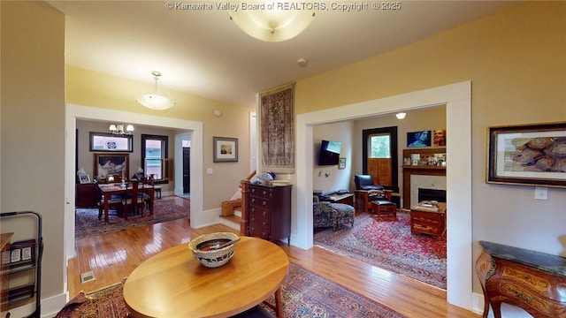 840 13th Ave, Huntington, WV 25701 - living room featuring wood finished floors, a chandelier, and a fireplace
