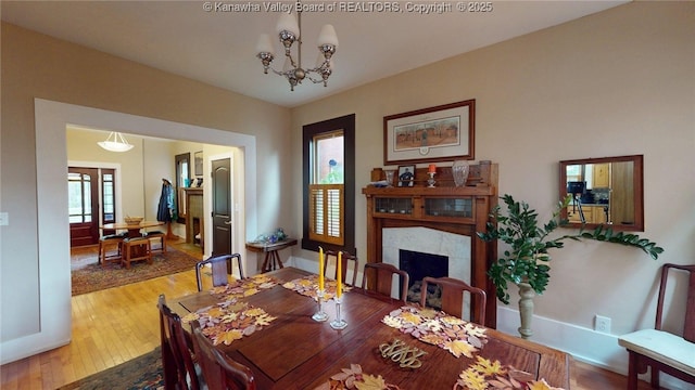 840 13th Ave, Huntington, WV 25701 - dining space with hardwood / wood-style flooring, a fireplace, and a chandelier