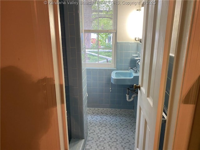 1407 Longridge Rd, Charleston, WV 25314 - bathroom featuring tile walls, a sink, a wainscoted wall, and a tile shower