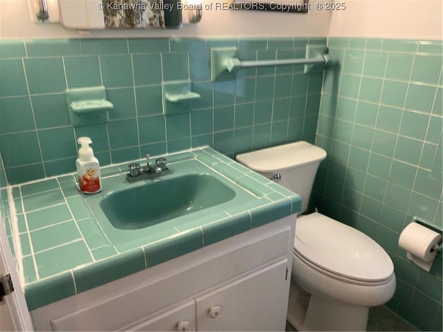 1407 Longridge Rd, Charleston, WV 25314 - half bathroom featuring tile walls, toilet, vanity, and a wainscoted wall
