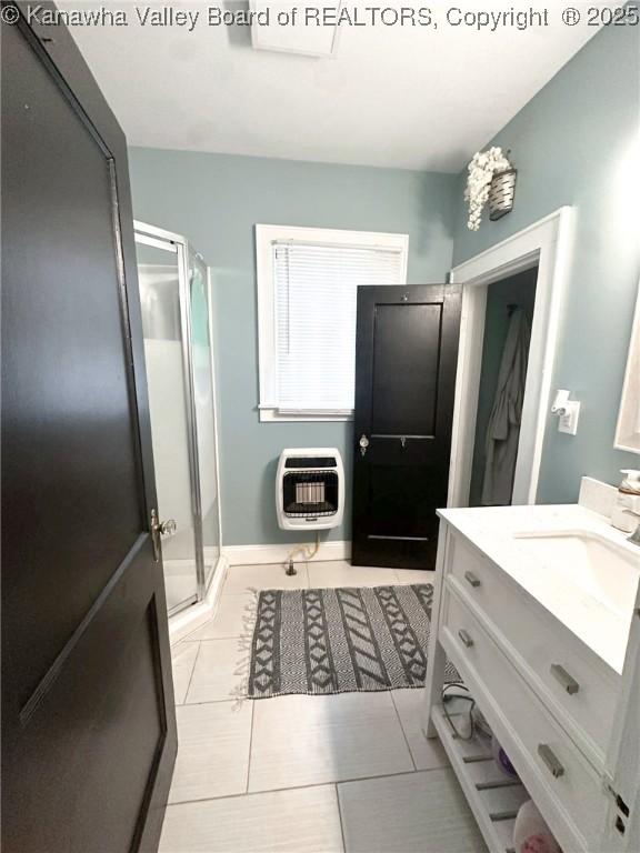 full bathroom with heating unit, a shower stall, vanity, and tile patterned floors