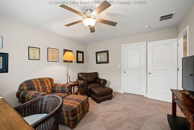 living area featuring a ceiling fan, carpet floors, and baseboards