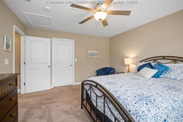 bedroom with light carpet, attic access, baseboards, and a ceiling fan