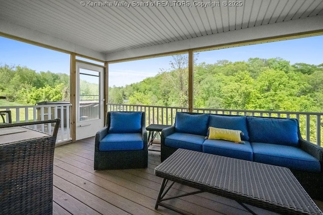 sunroom / solarium with outdoor lounge area and a view of trees