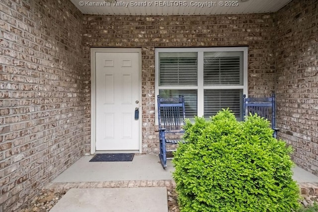 view of exterior entry with brick siding