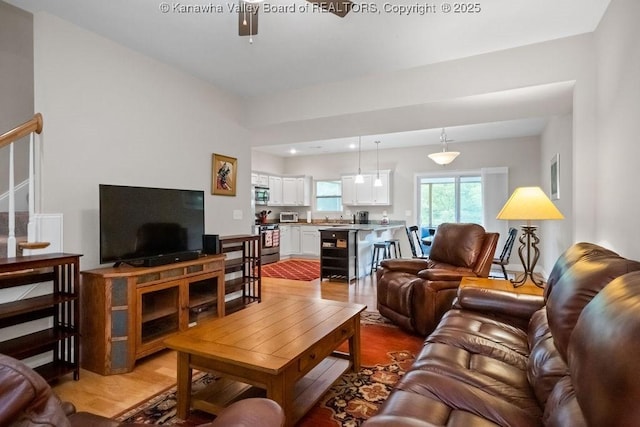 living area featuring light wood-style floors, a ceiling fan, and recessed lighting