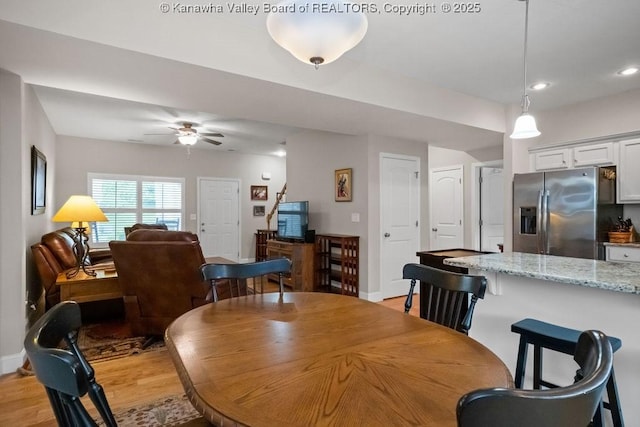 dining room with light wood finished floors, a ceiling fan, recessed lighting, and baseboards