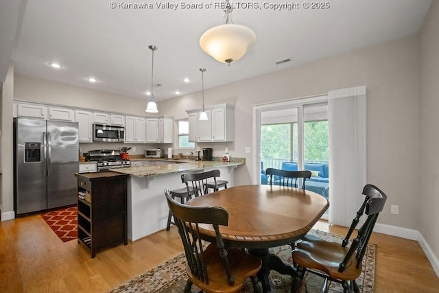 dining area with light wood finished floors, recessed lighting, and baseboards