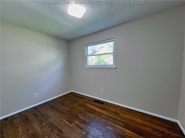 empty room with baseboards and dark wood-style floors