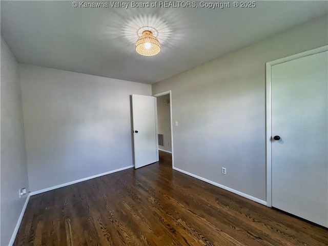 unfurnished bedroom featuring baseboards and wood finished floors