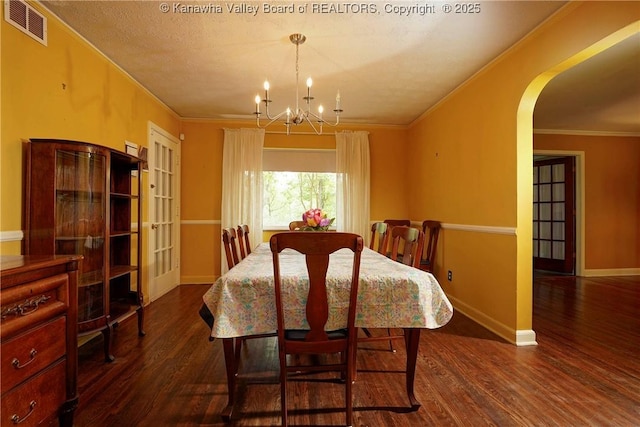 1518 Dogwood Rd, Charleston, WV 25314 - dining space with dark wood finished floors, a chandelier, arched walkways, crown molding, and baseboards