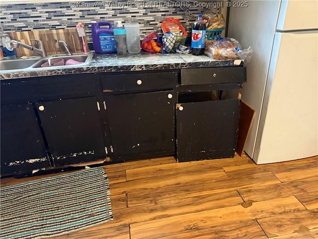 12027 Chap Rd, Wv, WV 25204 - detailed view of freestanding refrigerator, a sink, dark cabinets, and wood finished floors