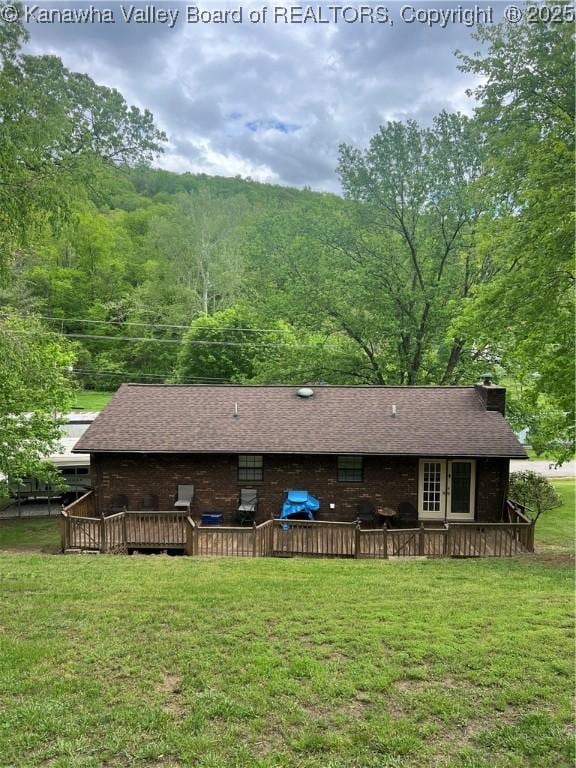 5222 Dalewood Dr, Charleston, WV 25313 - back of property with a wooden deck, a lawn, a wooded view, a chimney, and a shingled roof