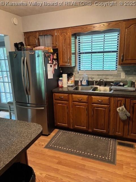 5222 Dalewood Dr, Charleston, WV 25313 - kitchen featuring freestanding refrigerator, dark countertops, a sink, and light wood finished floors
