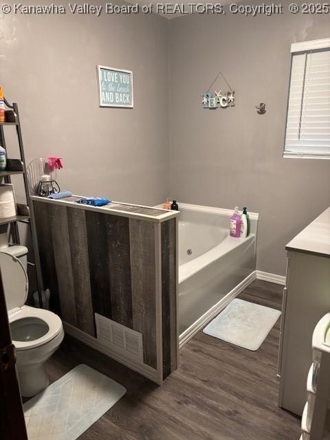 5222 Dalewood Dr, Charleston, WV 25313 - full bathroom featuring a jetted tub, wood finished floors, toilet, vanity, and baseboards