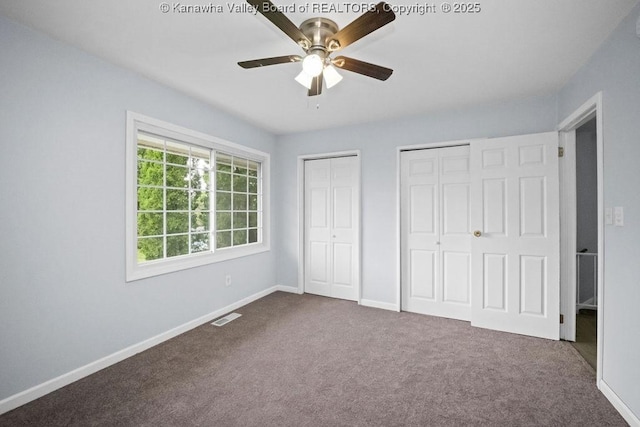 302 Charles Ct, Hurricane, WV 25526 - unfurnished bedroom with multiple closets, dark colored carpet, baseboards, and a ceiling fan