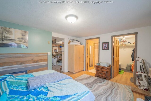 28 Tracy Ln, Summersville, WV 26651 - bedroom with wood finished floors, a walk in closet, a closet, and a textured ceiling