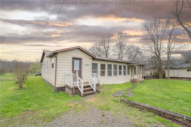 28 Tracy Ln, Summersville, WV 26651 - back of property at dusk with a lawn and a sunroom