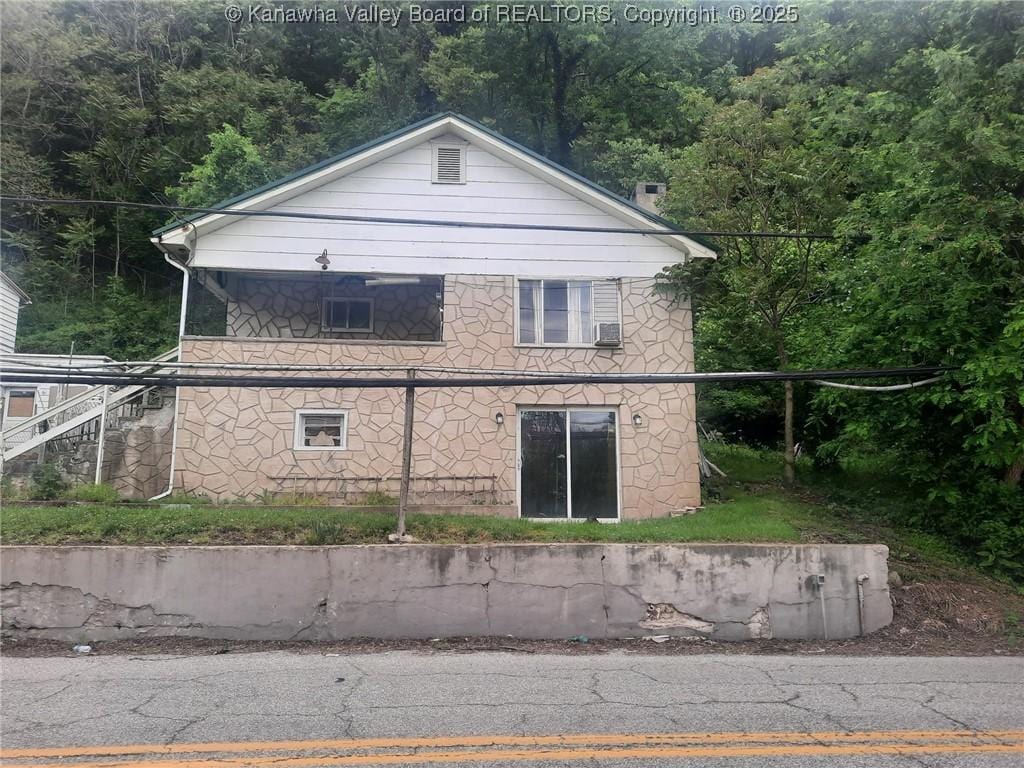 view of property exterior featuring a wooded view