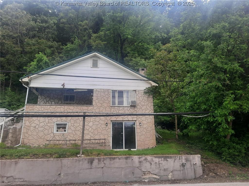 view of side of home featuring a view of trees