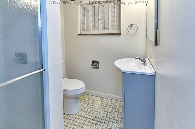 4010 Virginia Ave SE, Charleston, WV 25304 - bathroom featuring vanity, toilet, baseboards, and a shower with door