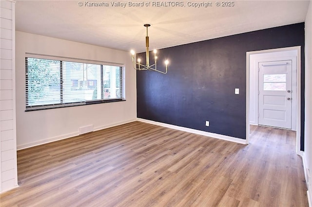 4010 Virginia Ave SE, Charleston, WV 25304 - unfurnished dining area featuring a chandelier, wood finished floors, and baseboards
