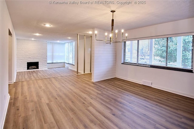 4010 Virginia Ave SE, Charleston, WV 25304 - unfurnished living room with a chandelier, wood finished floors, baseboards, healthy amount of natural light, and recessed lighting