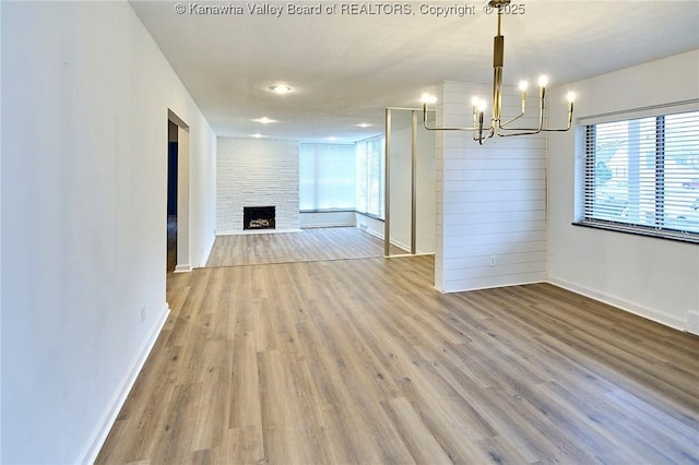 4010 Virginia Ave SE, Charleston, WV 25304 - unfurnished dining area featuring a chandelier, wood finished floors, baseboards, and a fireplace