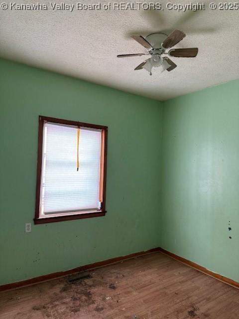 311 1/2 Westmoreland Dr, Charleston, WV 25302 - empty room featuring a textured ceiling, wood finished floors, baseboards, and a ceiling fan