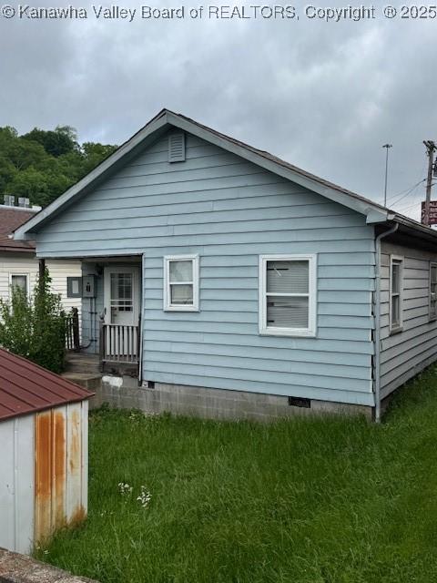 311 1/2 Westmoreland Dr, Charleston, WV 25302 - back of house with a yard, crawl space, a storage shed, and an outbuilding