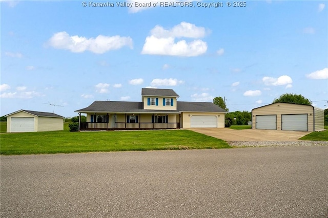 view of front of property featuring a front yard, covered porch, an outbuilding, and a detached garage