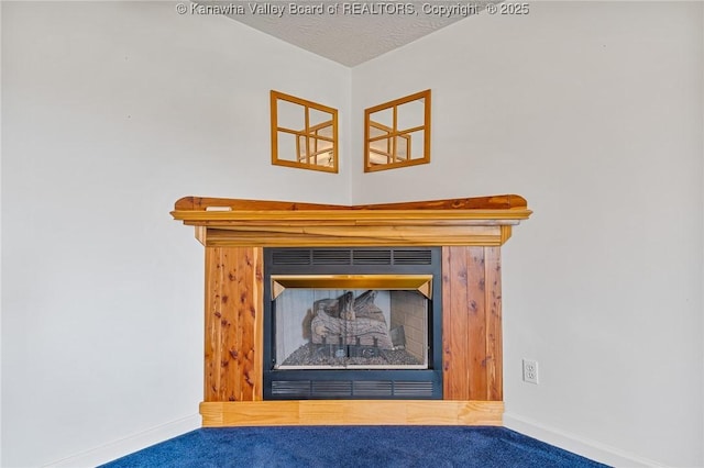 detailed view of carpet floors, baseboards, and a fireplace