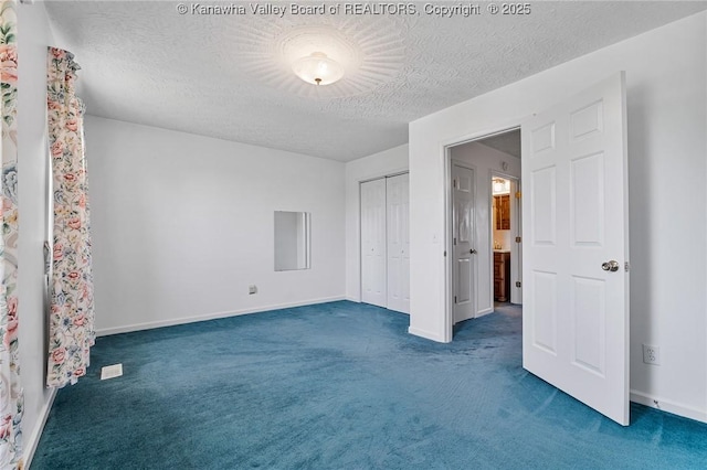 unfurnished bedroom featuring carpet floors, a textured ceiling, a closet, and baseboards