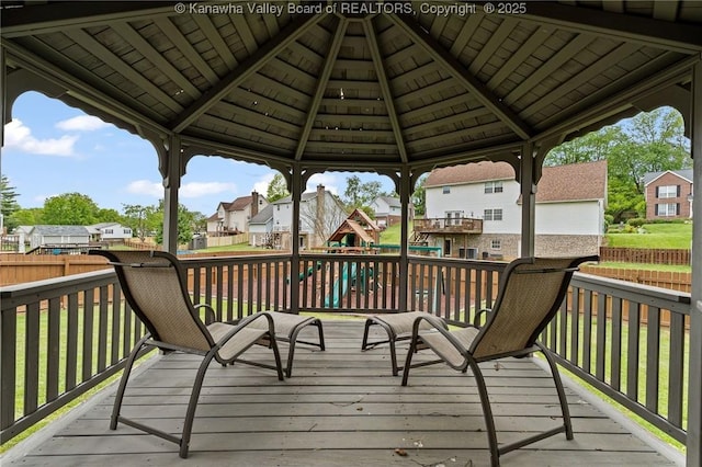 wooden deck featuring a residential view, a fenced backyard, and a playground