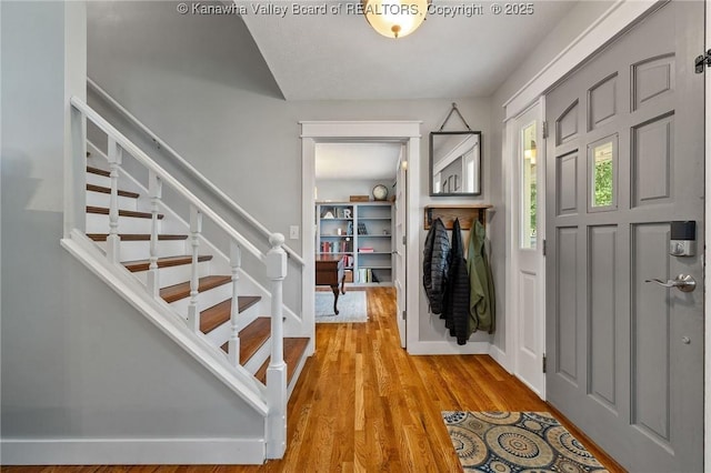 entrance foyer featuring stairs and light wood finished floors
