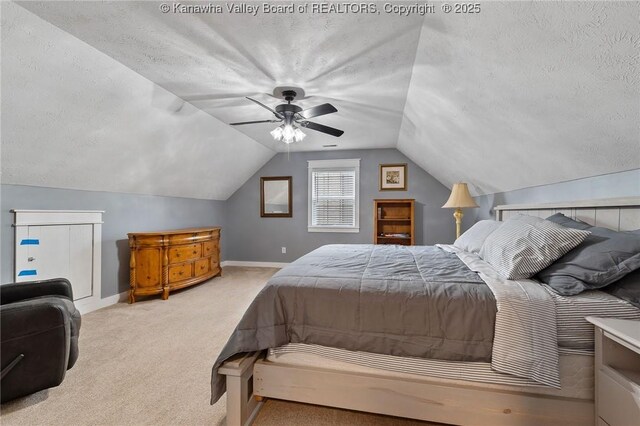 bedroom with a textured ceiling, carpet flooring, baseboards, vaulted ceiling, and ceiling fan