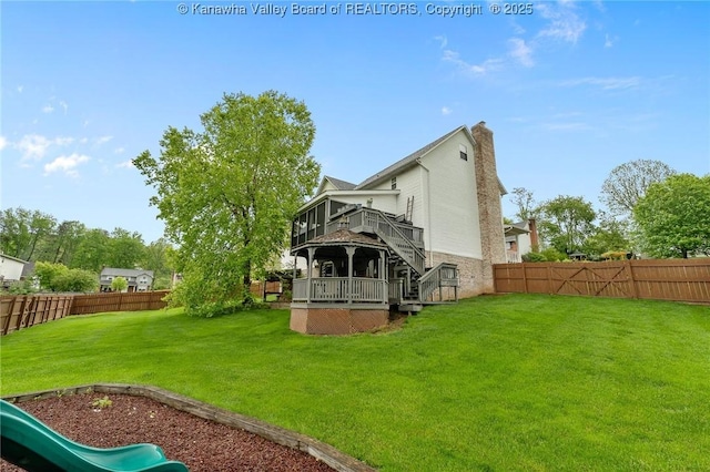 back of house featuring a deck, stairs, a chimney, and a playground