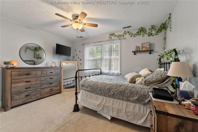 carpeted bedroom with a textured ceiling and ceiling fan