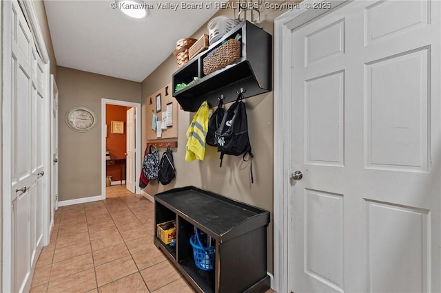 mudroom featuring light tile patterned floors and baseboards