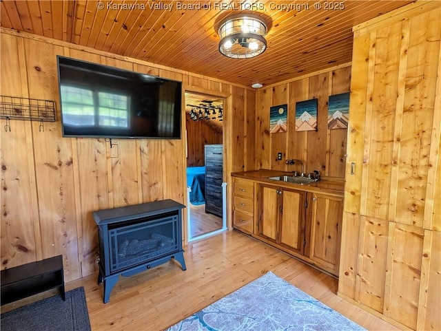 6531 Lockbridge Rd, Wv, WV 25976 - bar with wood ceiling, wooden walls, a sink, light wood-type flooring, and a wood stove