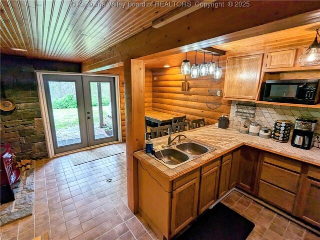 6531 Lockbridge Rd, Wv, WV 25976 - kitchen with black microwave, a sink, tile countertops, log walls, and french doors