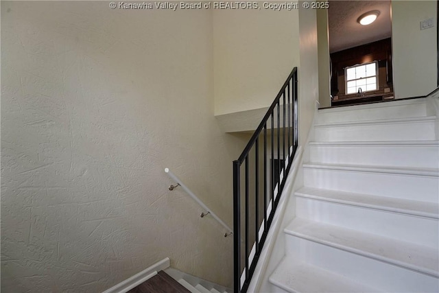 staircase featuring baseboards