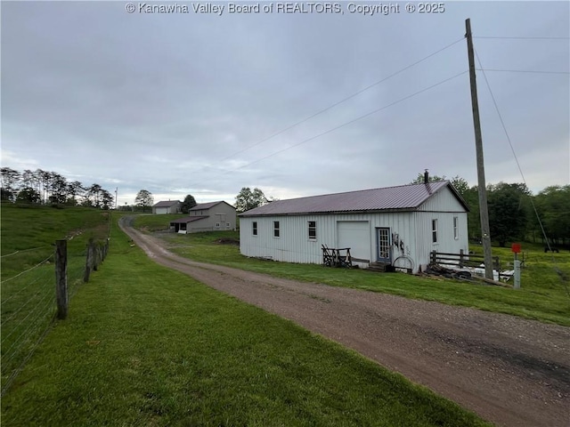 5860 Union Campground Rd, Letart, WV 25253 - view of side of property featuring board and batten siding, a detached garage, metal roof, and an outbuilding
