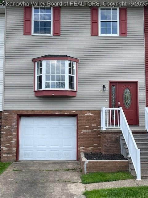 75 Geronimo Dr, Saint Albans, WV 25177 - view of front of home featuring a garage, brick siding, and concrete driveway