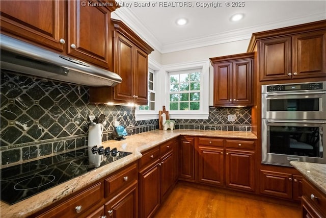 12 W Coventry Rd, South Charleston, WV 25309 - kitchen with stainless steel double oven, under cabinet range hood, light stone countertops, wood finished floors, and tasteful backsplash