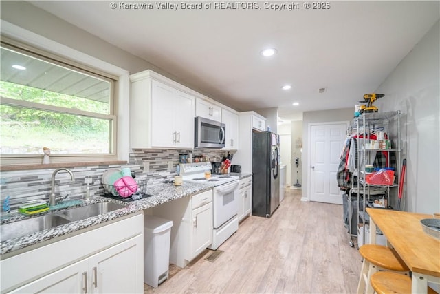 2611 Larwood Dr, Charleston, WV 25302 - kitchen featuring white electric stove, stainless steel microwave, black refrigerator with ice dispenser, a sink, and tasteful backsplash