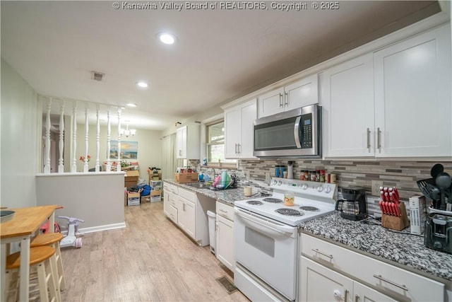 2611 Larwood Dr, Charleston, WV 25302 - kitchen featuring stainless steel microwave, electric stove, light wood finished floors, recessed lighting, and decorative backsplash