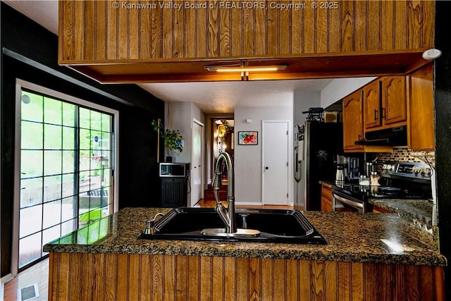 5427 Hillbrook Dr, Charleston, WV 25313 - kitchen featuring stainless steel appliances, a sink, under cabinet range hood, brown cabinets, and dark countertops