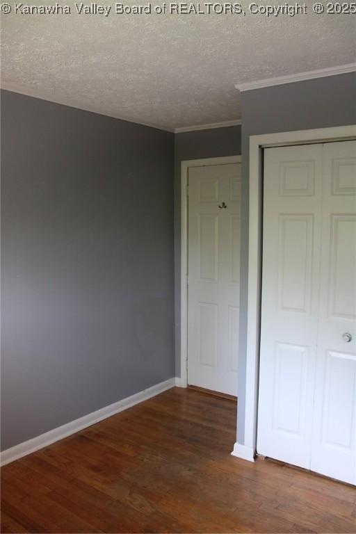 1741 Huber Rd, Charleston, WV 25314 - unfurnished bedroom with wood finished floors, a closet, ornamental molding, a textured ceiling, and baseboards